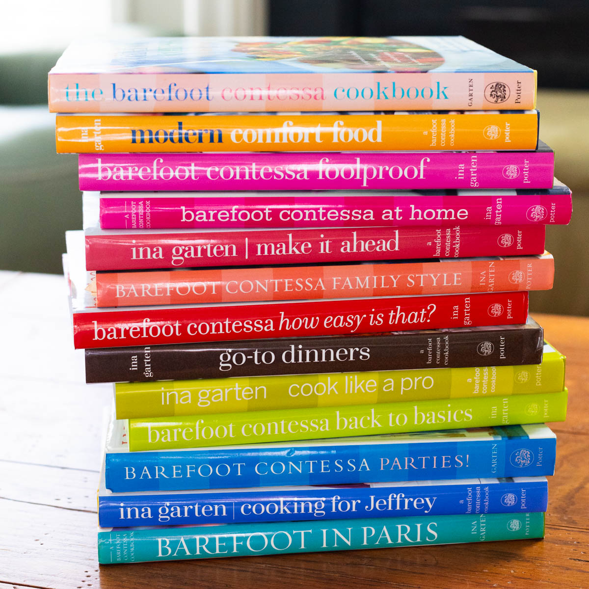 All of Ina Garten's Barefoot Contessa cookbooks are in a stack on the table.