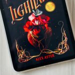 The cover of Lightlark by Alex Aster is on the screen of an ipad.