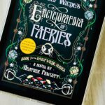 The cover of the book Emily Wilde's Encyclopaedia of Faeries by Heather Fawcett is on the screen of an iPad.