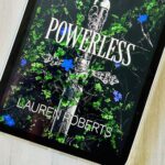 The cover of the book Powerless by Lauren Roberts is on the screen of an iPad.