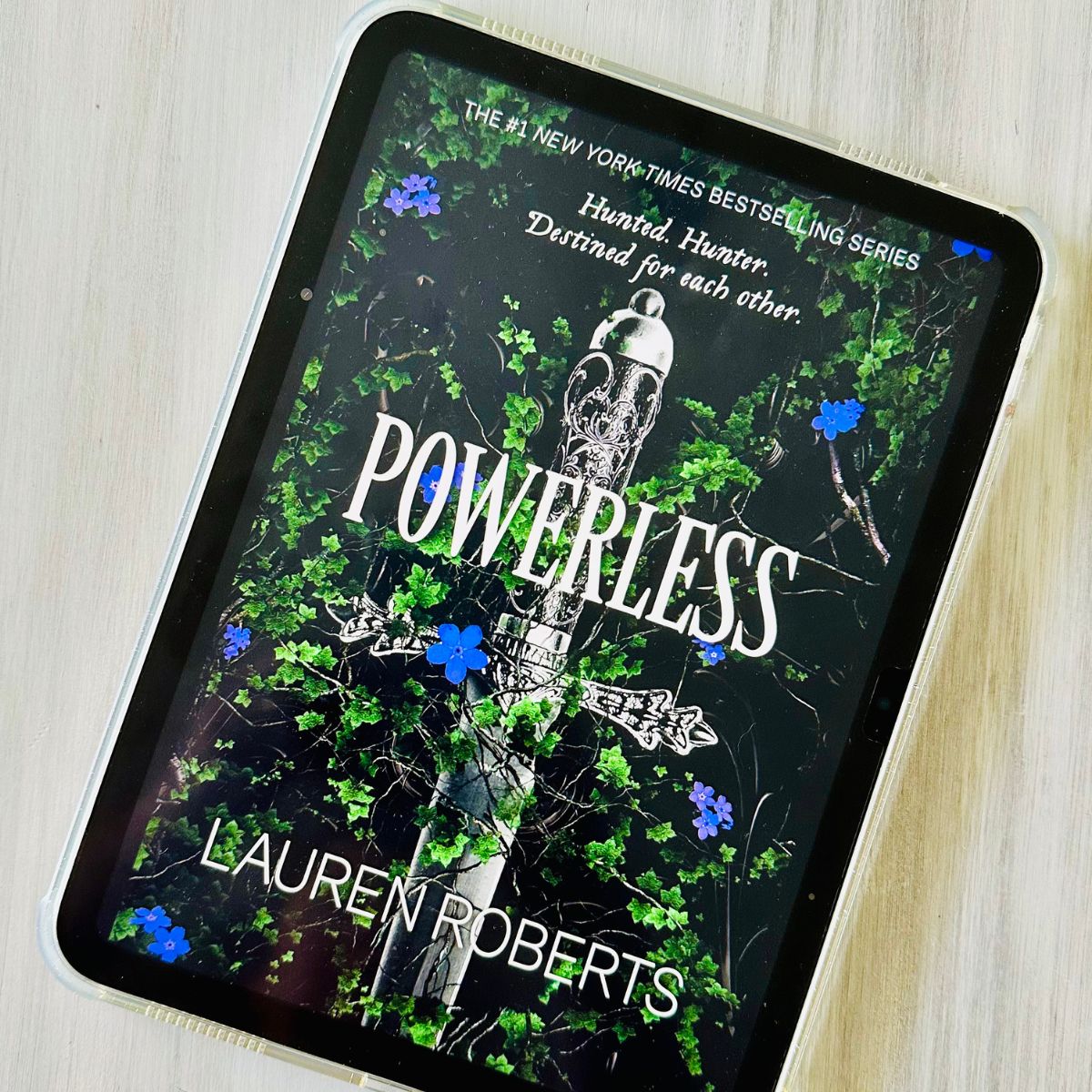 The cover of the book Powerless by Lauren Roberts is on the screen of an iPad.