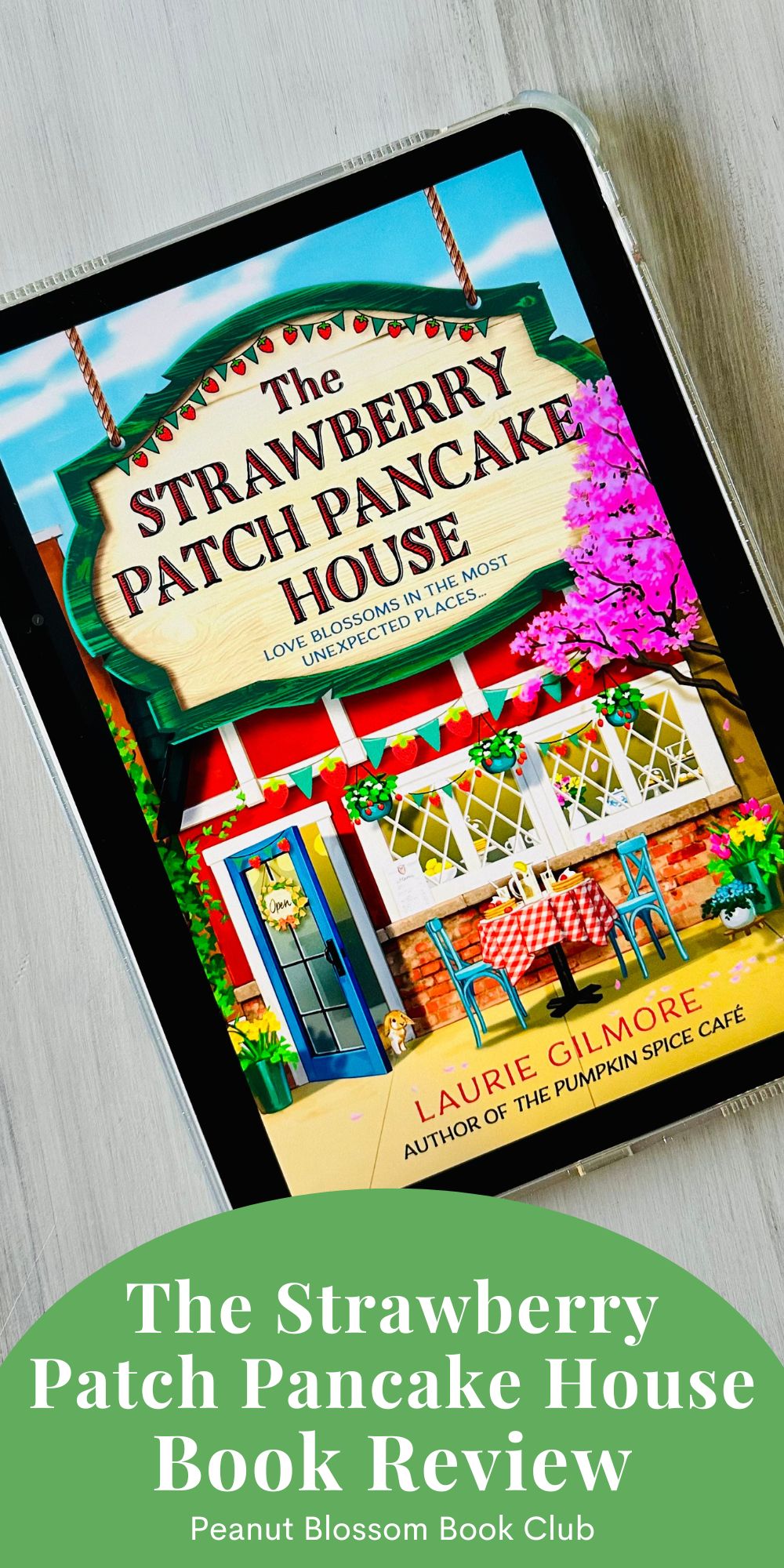 The cover of the book The Strawberry Patch Pancake House by Laurie Gilmore is on the screen of an ipad.