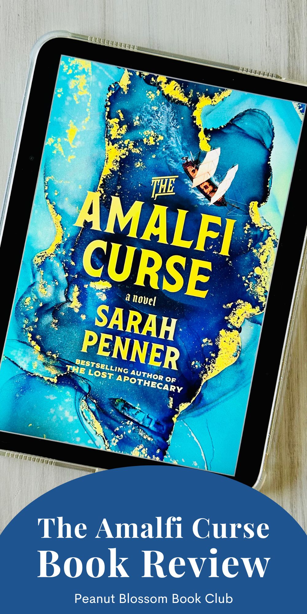 The cover of the book The Amalfi Curse by Sarah Penner is on the screen of an iPad.