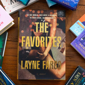 A copy of the book The Favorites by Layne Fargo sits on the table.